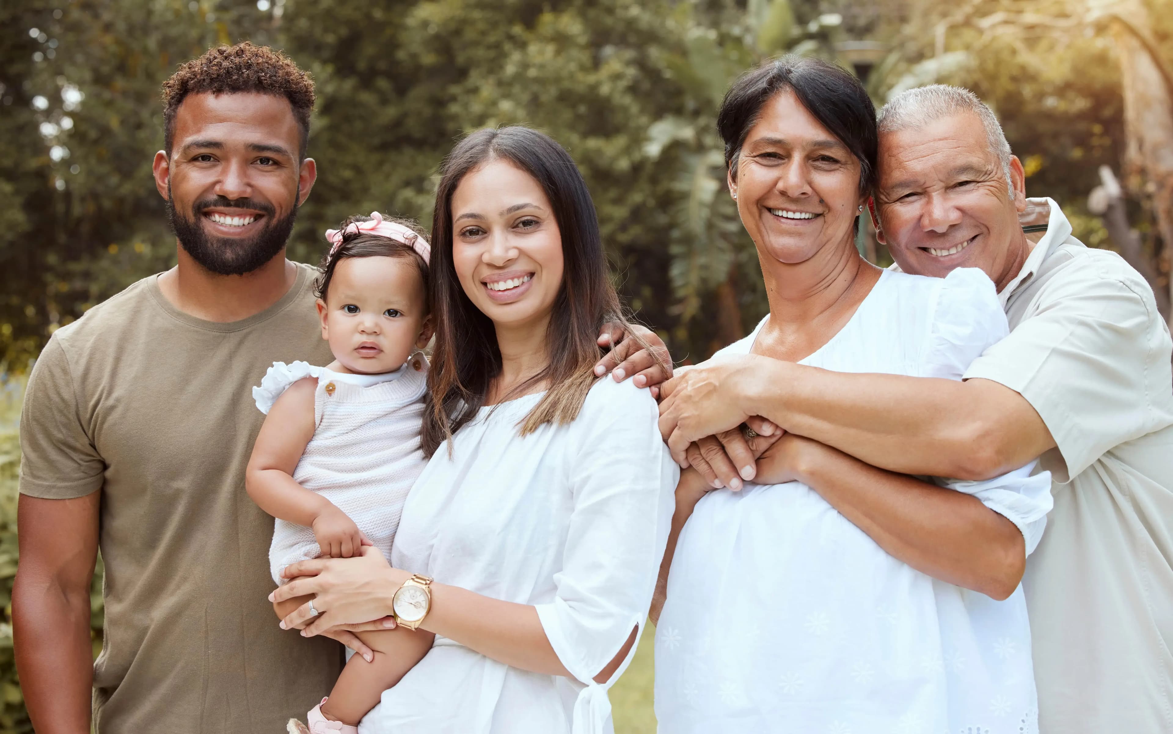 Multi-generational family smiling together in a natural setting